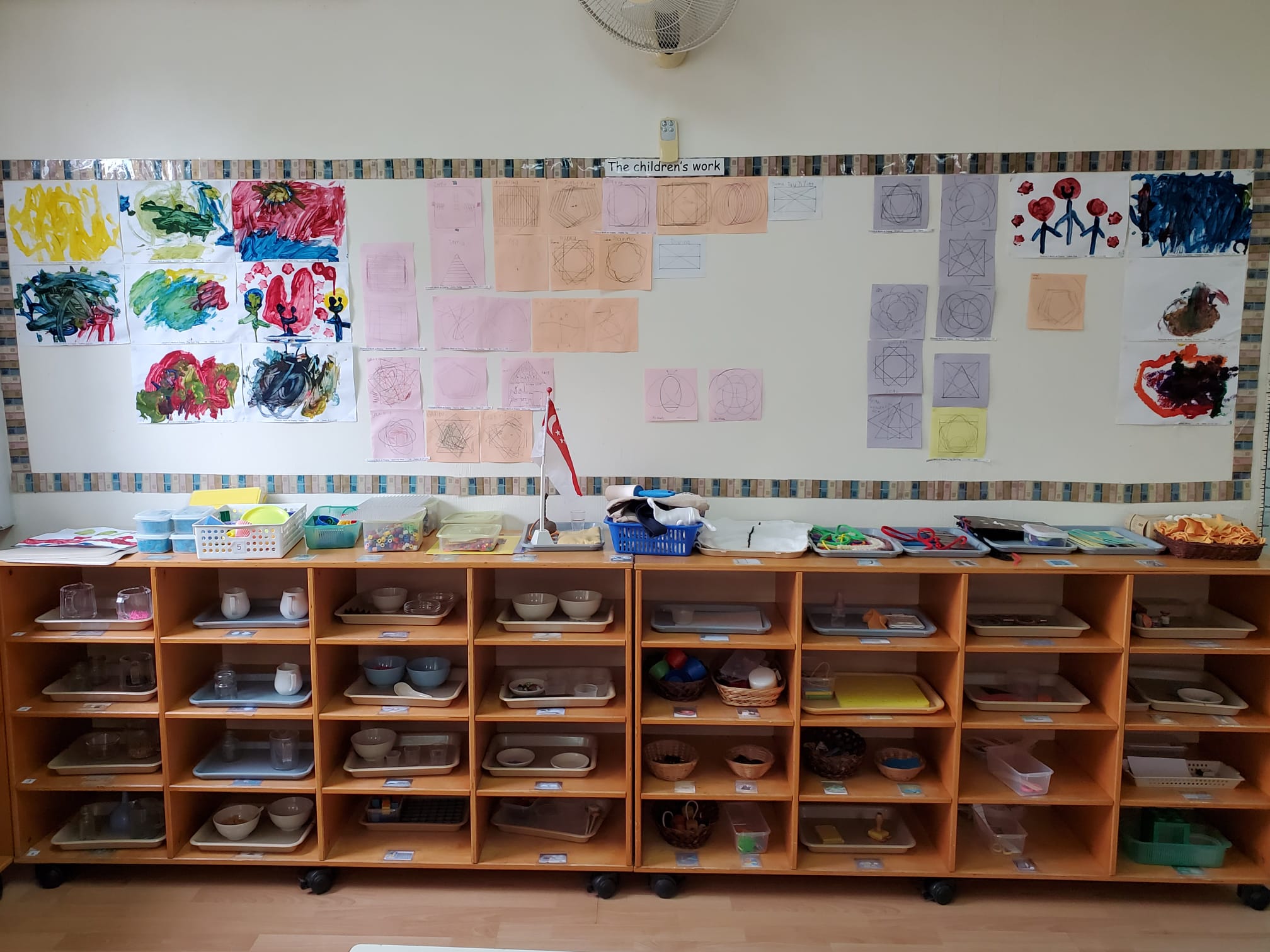Montessori shelves and children's artwork at dMP